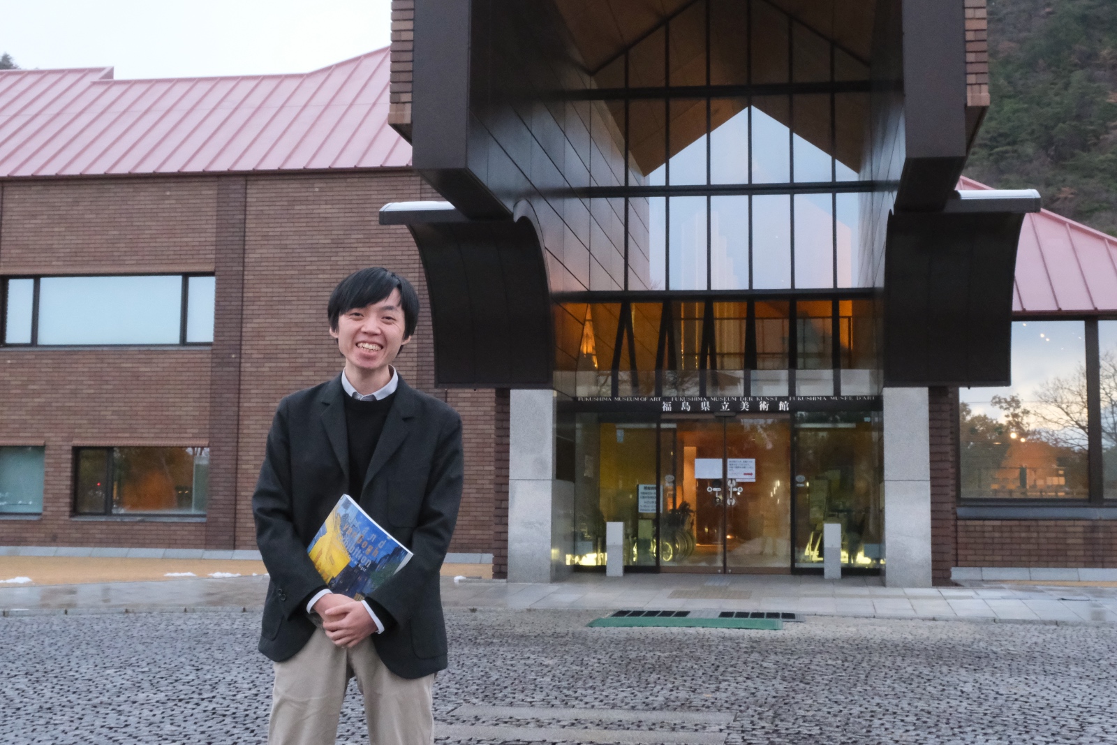 美術館を前に、学芸員・濱田さん